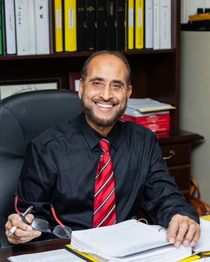 Dr. Hassan at his desk reviewing project documents